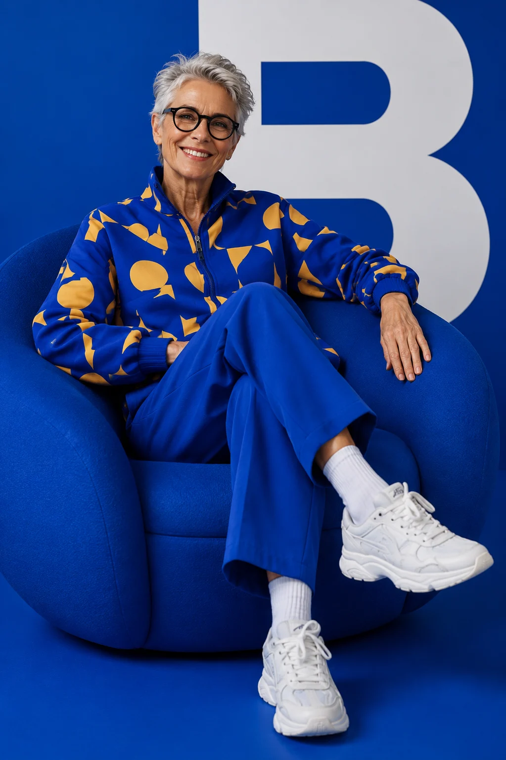 Contemporary blue studio portrait with sculptural chair and modern fashion styling.
