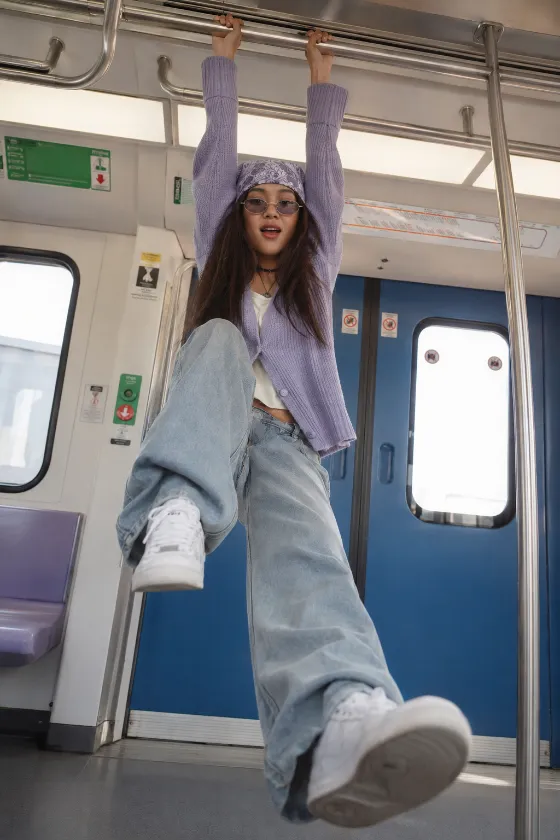 Low-angle metro fashion editorial with suspended pose.