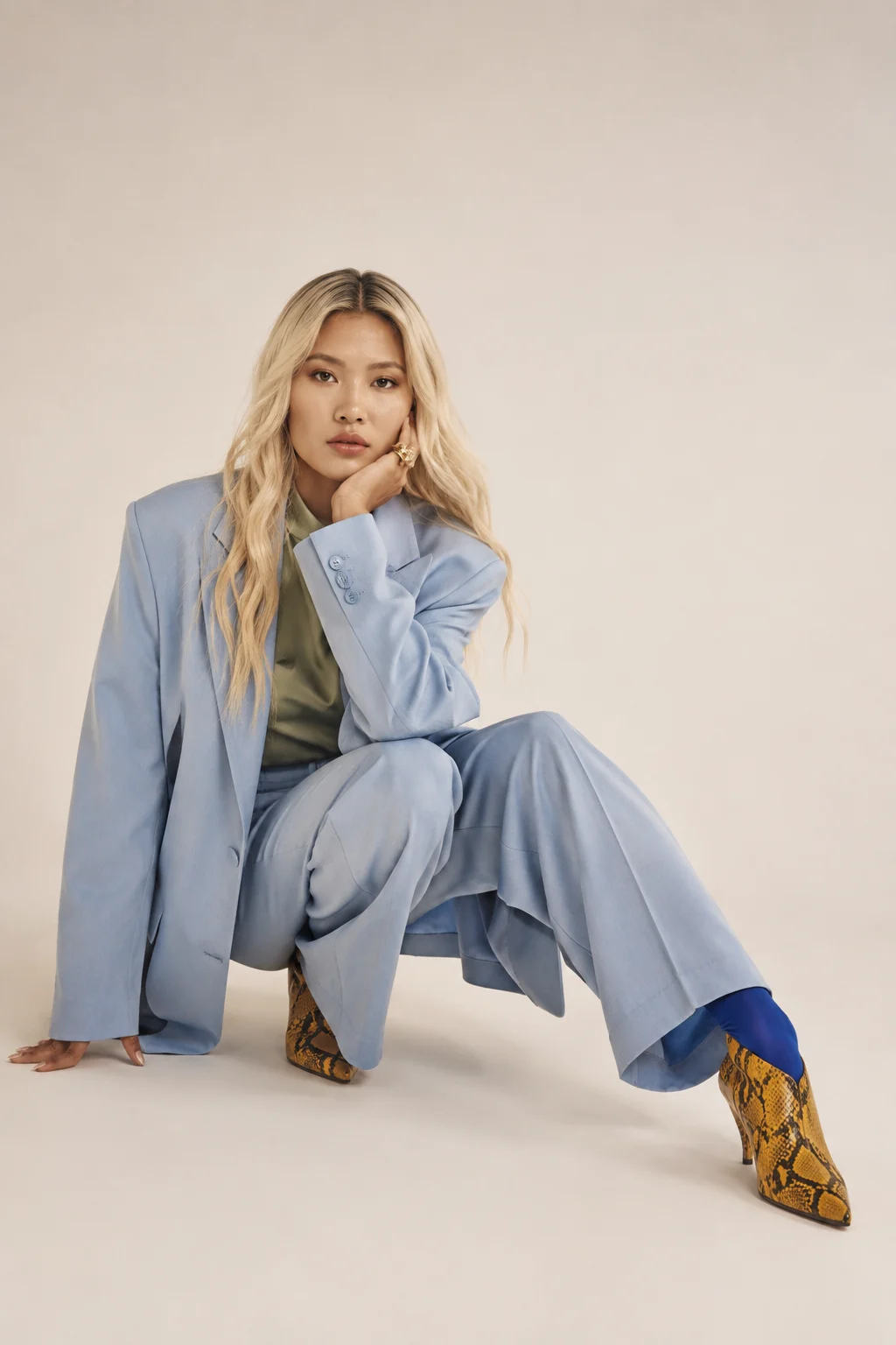 Editorial fashion portrait with oversized powder-blue suit and sculptural pose.