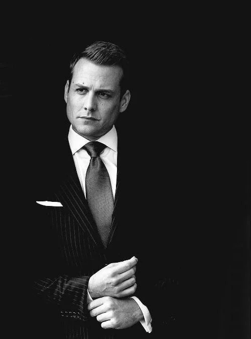 Editorial monochrome portrait with luxury tailoring and deep black background.