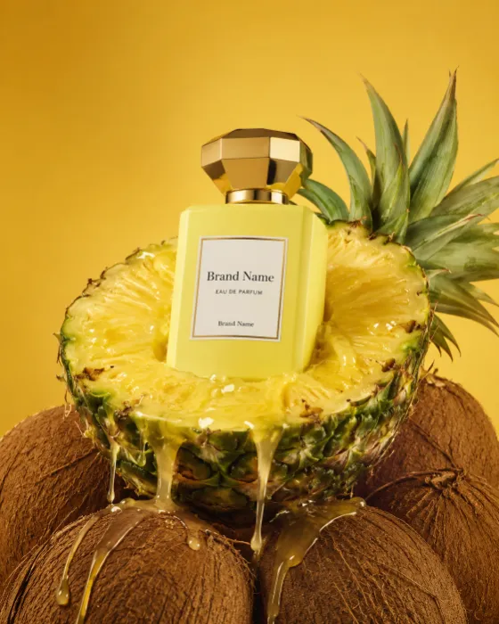 Luxury perfume bottle in a pineapple with flowing juice on a golden studio background.