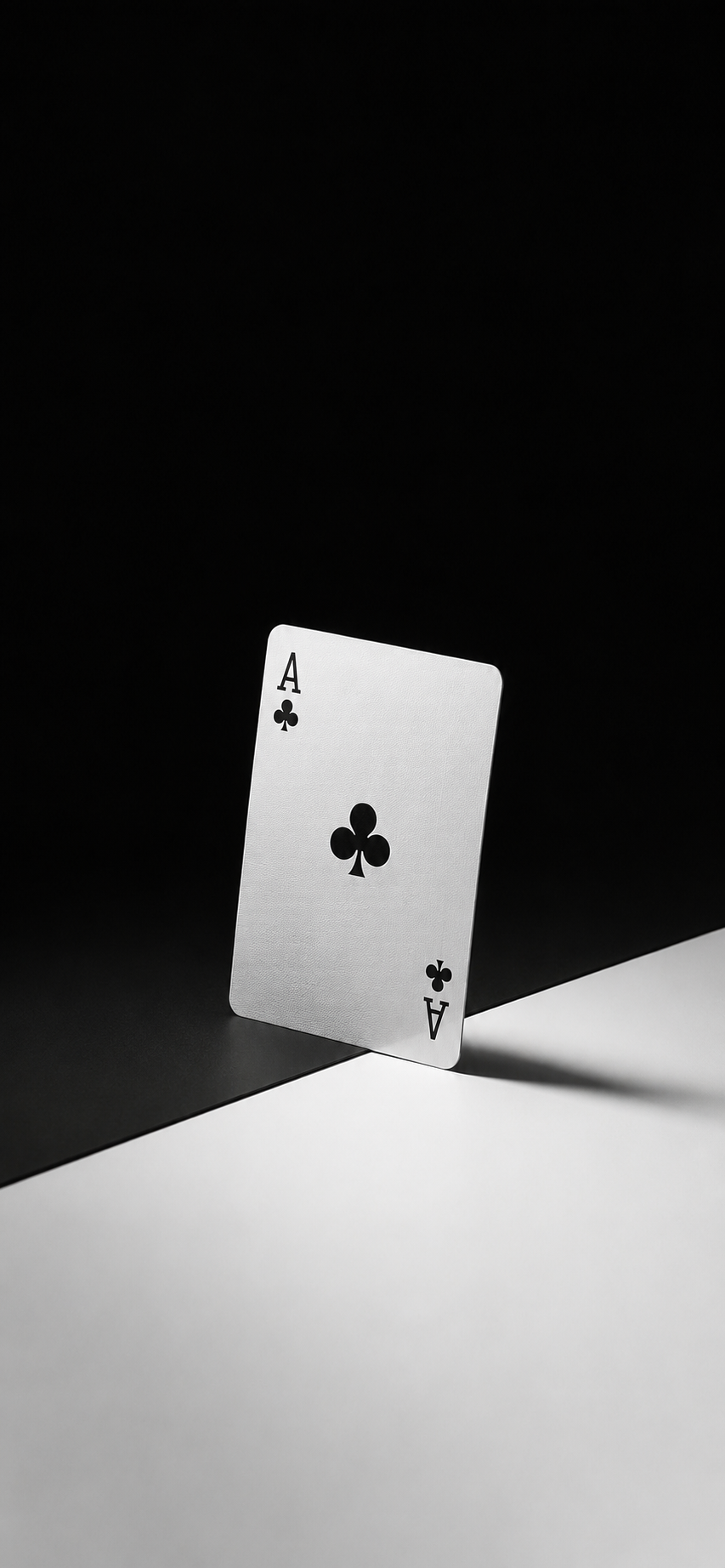 A single Ace of Clubs playing card standing on a minimalist black-and-white studio background.