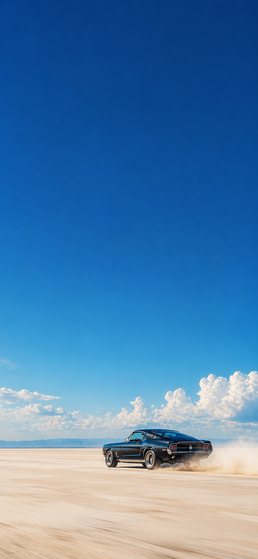 Classic dark muscle car driving across a minimalist landscape beneath a vast blue sky with white clouds.