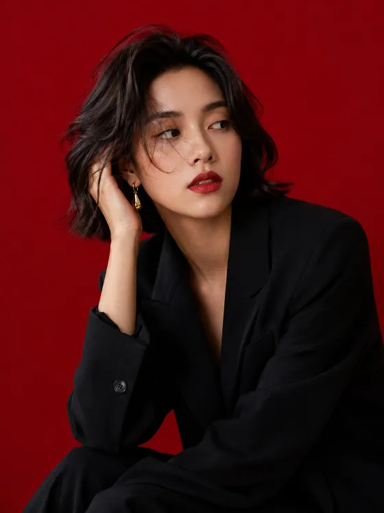 Minimal fashion portrait with red background and black blazer.