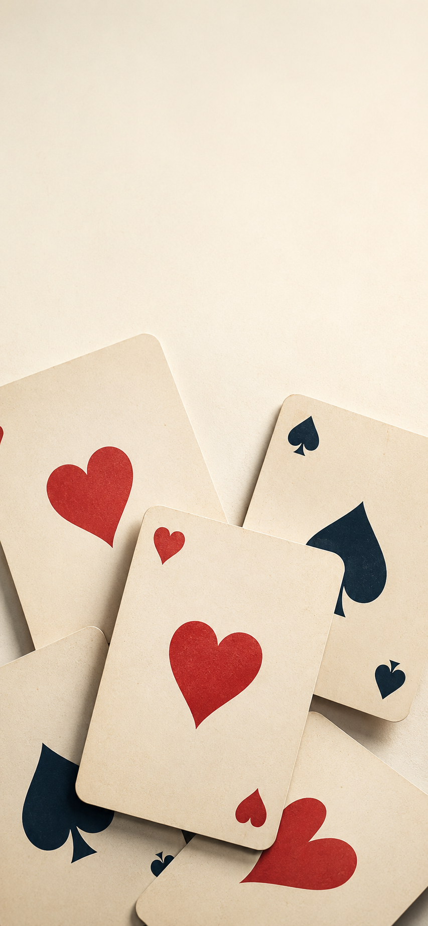 Layered playing cards with red hearts and black spades arranged as a premium minimalist wallpaper.