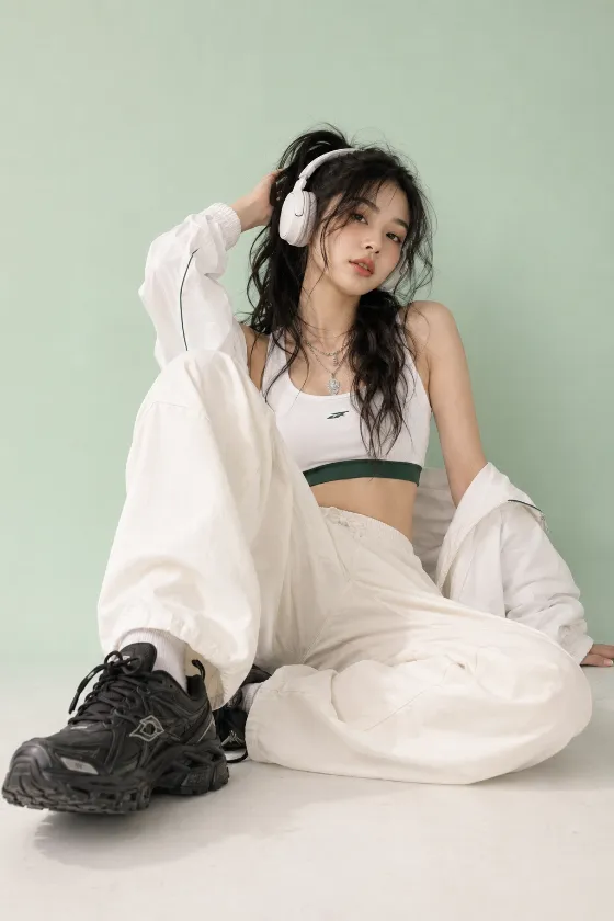 White headphone streetwear outfit with cream cargo pants, oversized white jacket, and chunky black sneakers