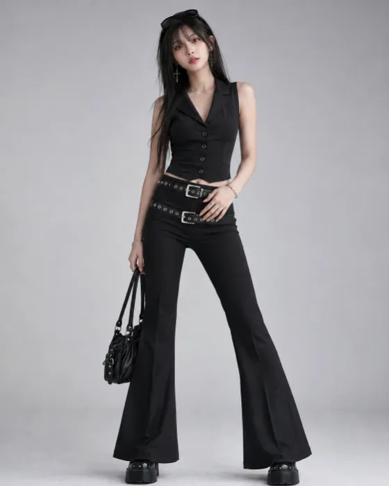 Vertical fashion portrait featuring a black fitted vest, wide flared trousers, layered belts, silver jewelry, sunglasses, platform footwear, and a compact handbag.