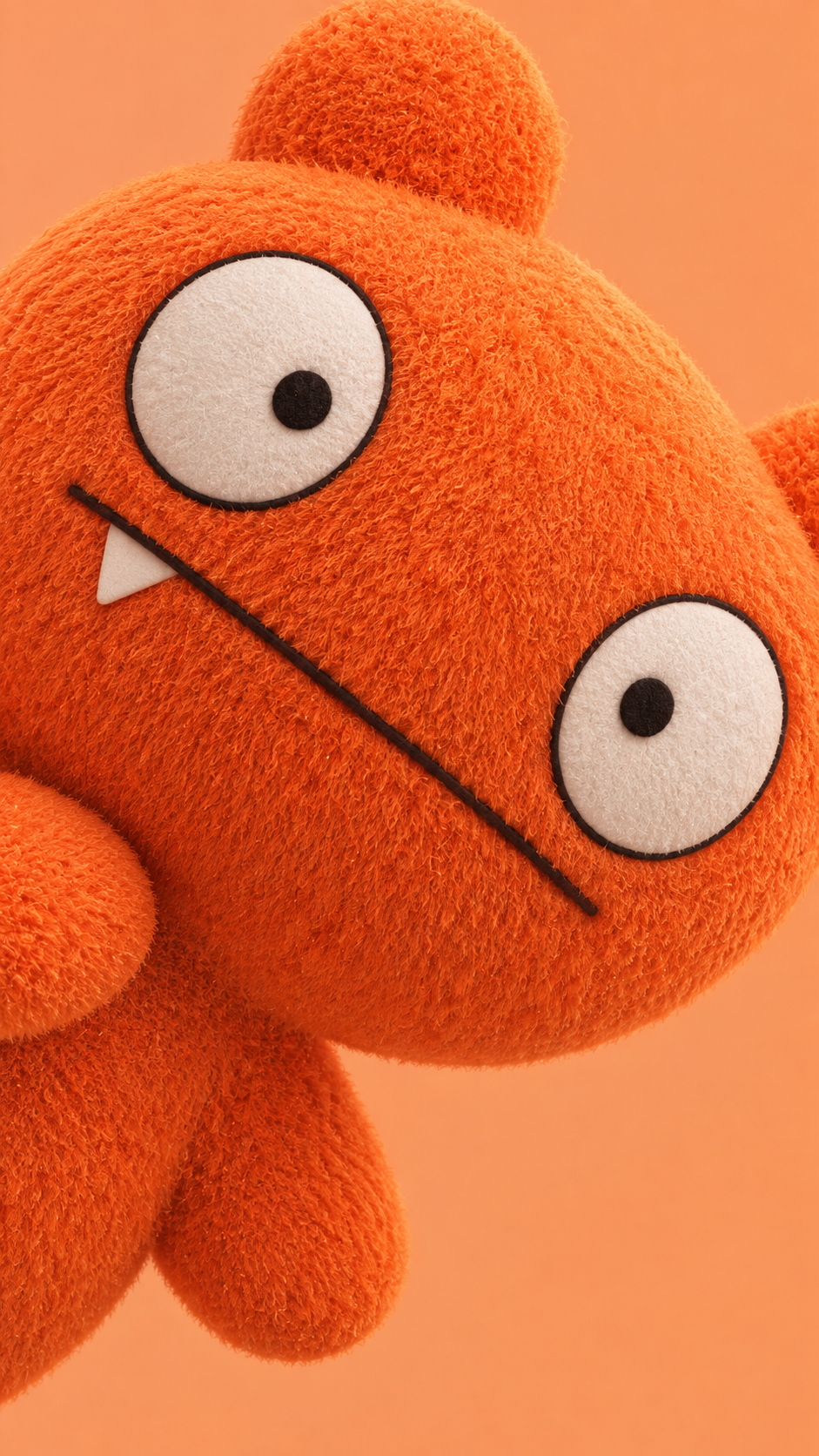 Oversized fuzzy orange teddy bear with large white eyes on a peach phone wallpaper background.