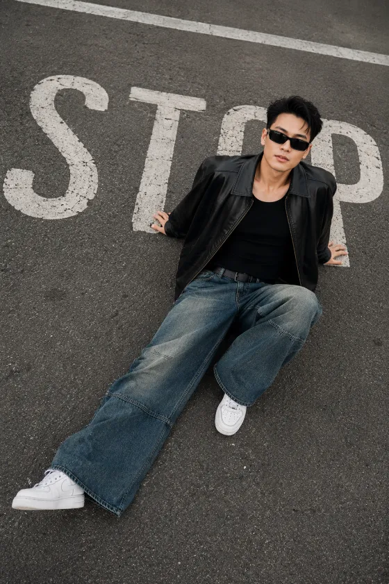 High-angle street editorial featuring relaxed fashion styling on an urban roadway.