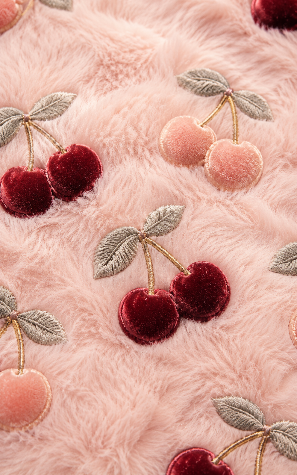 Plush cherry embroidery pattern on pale pink faux fur with burgundy cherries, peach cherries, gray leaves, and gold stems.