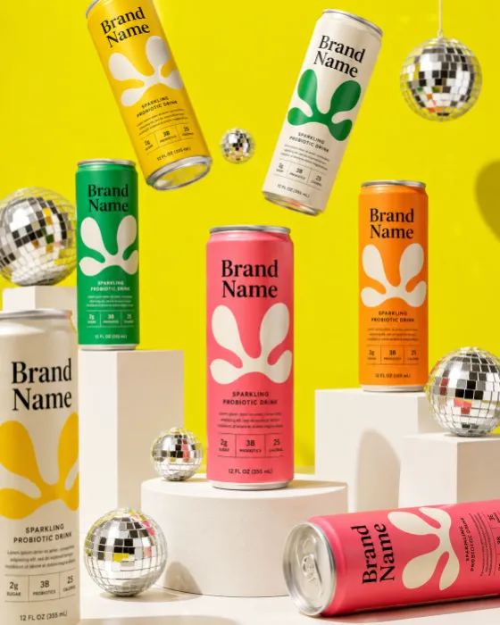 A colorful collection of premium beverage cans displayed on white geometric platforms against a vibrant yellow studio background with mirrored disco balls.