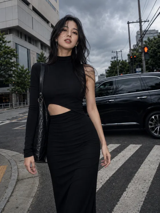 Vertical street-fashion portrait of a model wearing a long black cutout dress at an urban intersection.